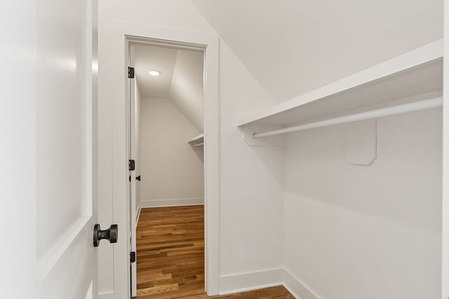 walk in closet with vaulted ceiling and hardwood / wood-style floors