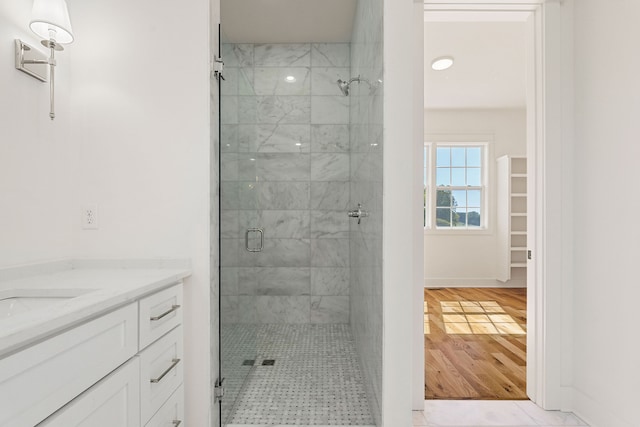 bathroom with a shower with door, vanity, and wood-type flooring