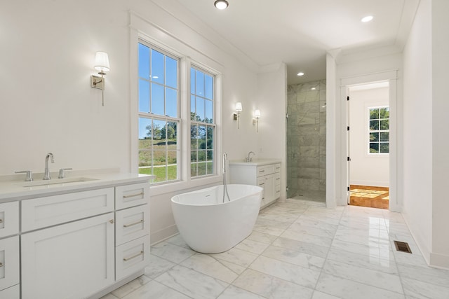 bathroom featuring a wealth of natural light, ornamental molding, separate shower and tub, and vanity