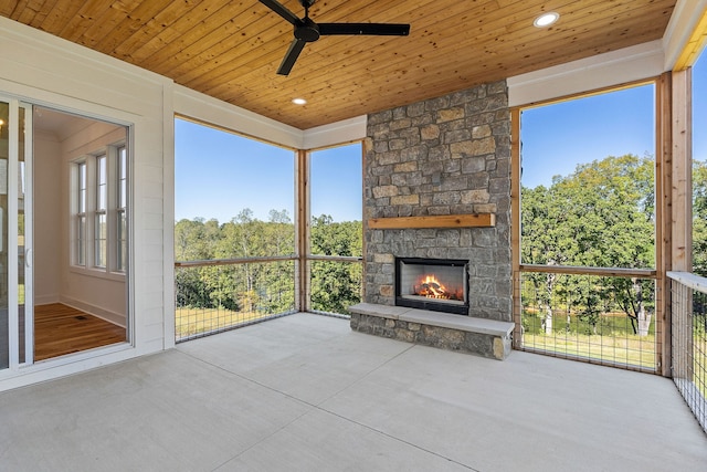 unfurnished sunroom featuring a fireplace, wood ceiling, and a wealth of natural light