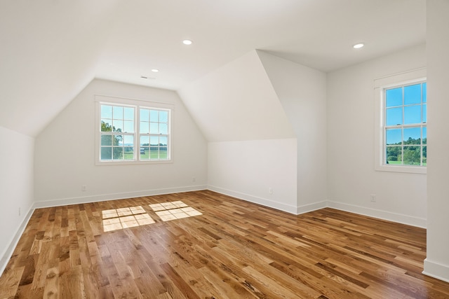 bonus room with lofted ceiling and hardwood / wood-style floors