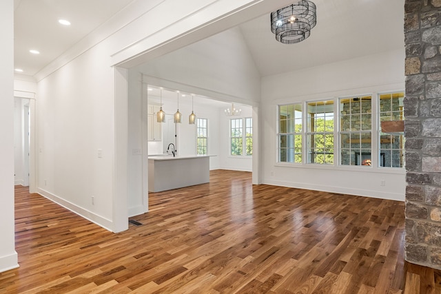 interior space featuring crown molding, hardwood / wood-style floors, sink, and vaulted ceiling