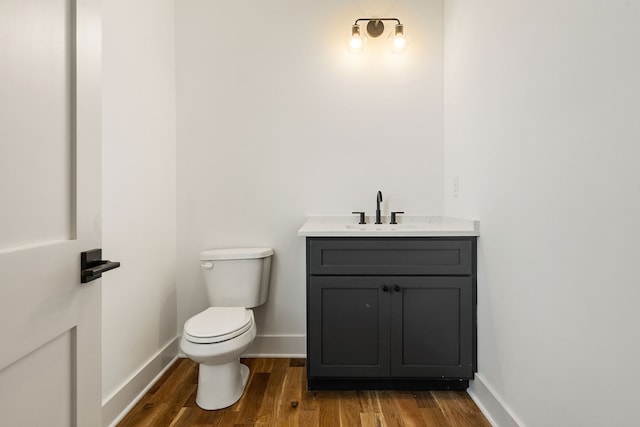 bathroom with vanity, toilet, and wood-type flooring