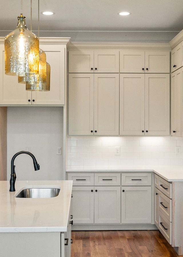 kitchen with decorative light fixtures, dark hardwood / wood-style floors, sink, and decorative backsplash