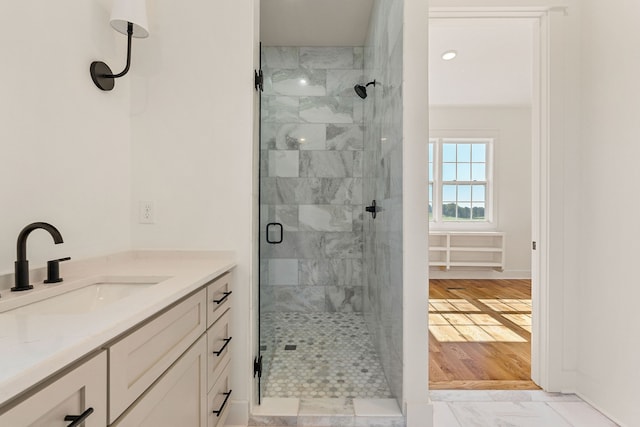 bathroom with hardwood / wood-style flooring, vanity, and a shower with shower door