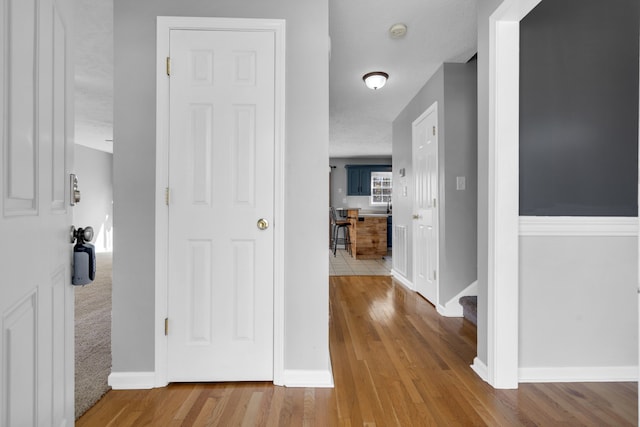 hall with a textured ceiling and hardwood / wood-style flooring