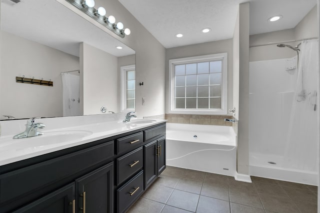 bathroom with vanity, a textured ceiling, tile patterned floors, and plus walk in shower