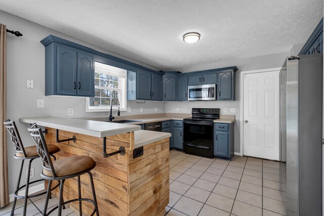 kitchen featuring blue cabinets, sink, and stainless steel appliances