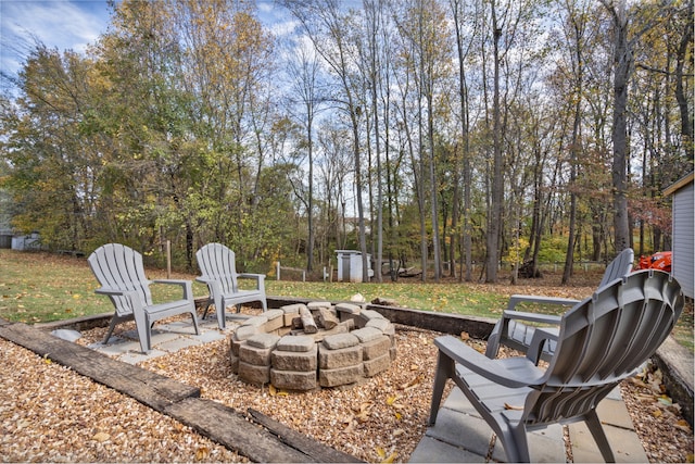 view of patio featuring an outdoor fire pit and a storage shed