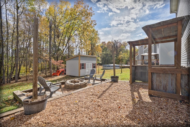 view of yard featuring a pergola, an outdoor fire pit, and an outbuilding