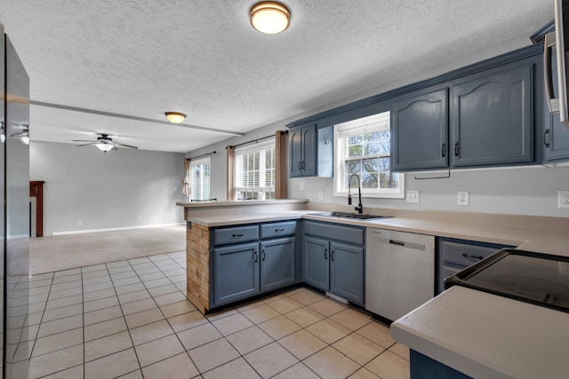 kitchen with blue cabinets, dishwasher, kitchen peninsula, sink, and ceiling fan