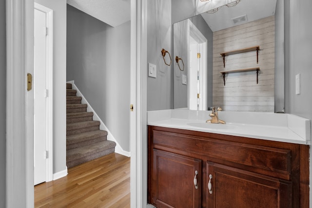 bathroom with a textured ceiling, vanity, and hardwood / wood-style flooring