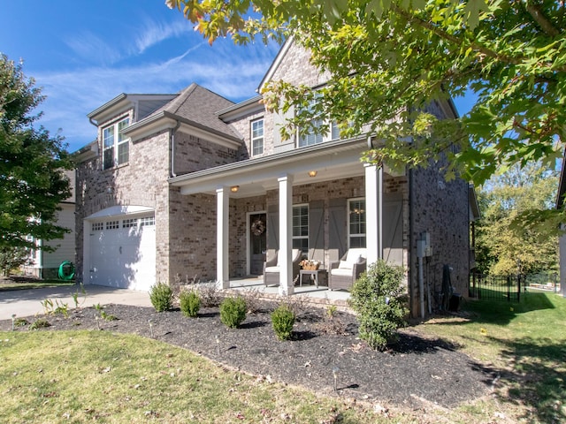 view of front facade featuring a front yard, a garage, and covered porch