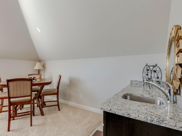 carpeted dining area with lofted ceiling and sink