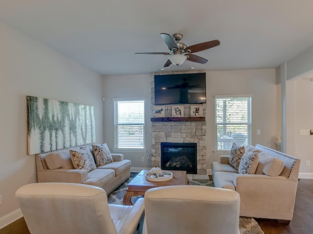 living room with dark wood-type flooring, a fireplace, a wealth of natural light, and ceiling fan