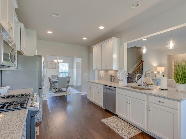 kitchen with sink, light stone countertops, dark hardwood / wood-style floors, white cabinets, and appliances with stainless steel finishes