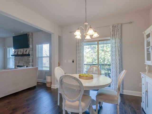 dining room with a wealth of natural light, dark wood-type flooring, and a chandelier