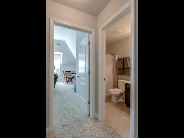 corridor featuring light carpet and lofted ceiling