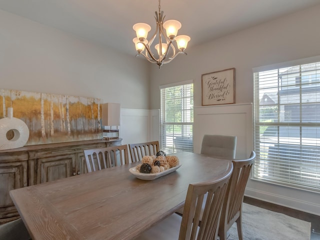 dining area featuring plenty of natural light, hardwood / wood-style floors, and an inviting chandelier