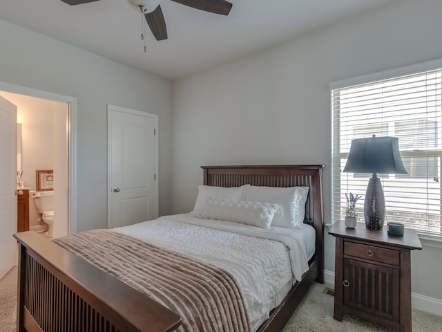 carpeted bedroom with ceiling fan and ensuite bath