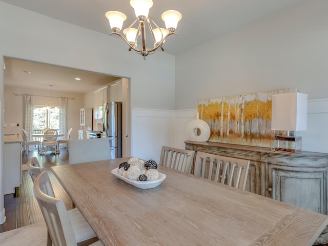 dining space featuring hardwood / wood-style floors and an inviting chandelier