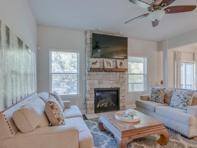 living room featuring a fireplace, ceiling fan, and a healthy amount of sunlight