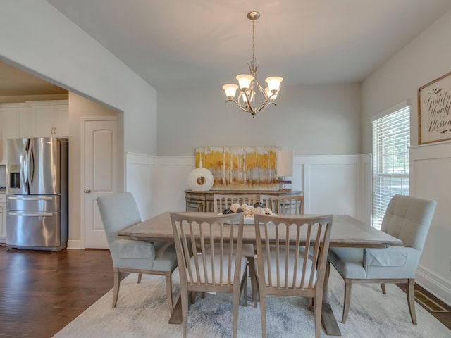 dining area with an inviting chandelier and dark wood-type flooring