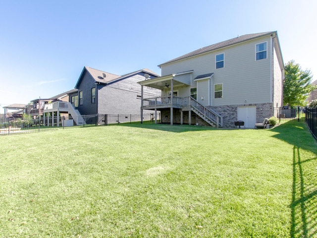 back of property featuring a wooden deck and a lawn