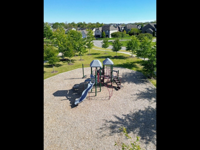 view of home's community featuring a playground and a yard