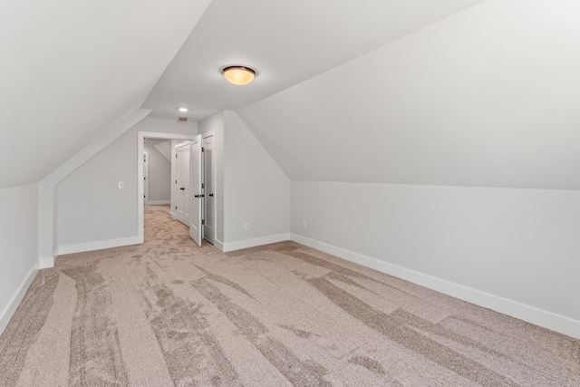 bonus room featuring light carpet and vaulted ceiling