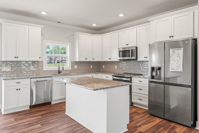 kitchen with backsplash, sink, stainless steel appliances, dark hardwood / wood-style floors, and white cabinetry