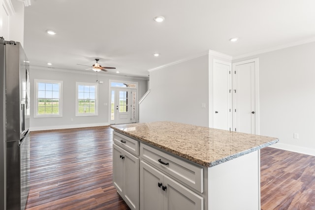 kitchen featuring ornamental molding, stainless steel refrigerator, dark wood-type flooring, and a center island