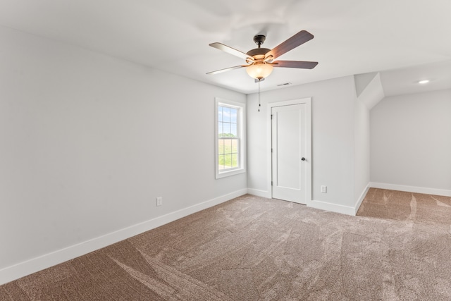 empty room with ceiling fan and light carpet