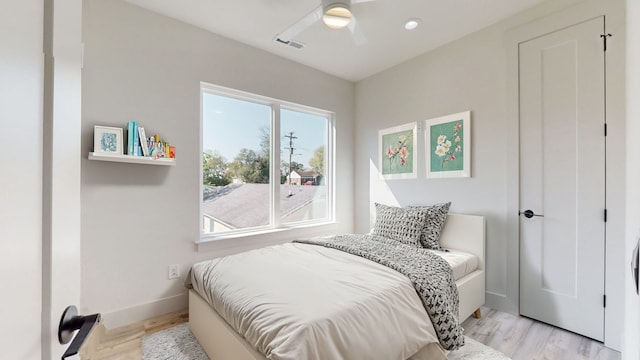 bedroom featuring visible vents, baseboards, light wood-style floors, and a ceiling fan