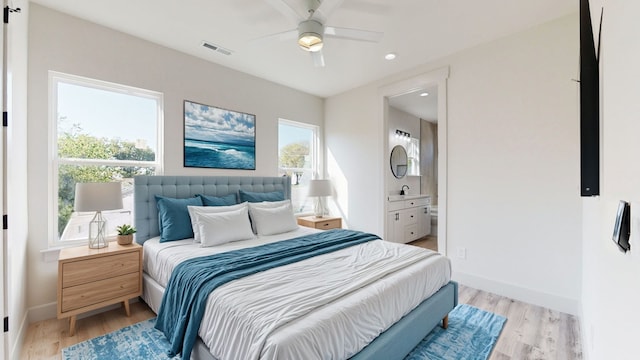 bedroom with ceiling fan, connected bathroom, and light hardwood / wood-style floors