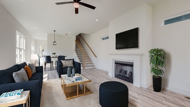 living room featuring light wood-type flooring and ceiling fan