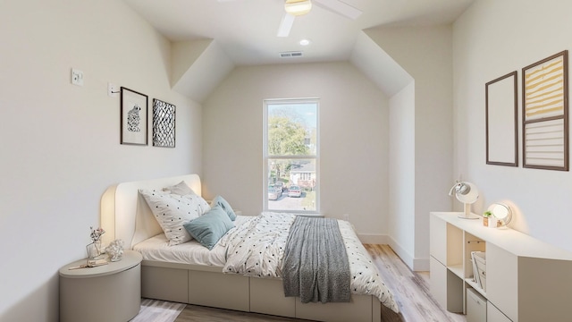 bedroom featuring ceiling fan, light wood-type flooring, and vaulted ceiling