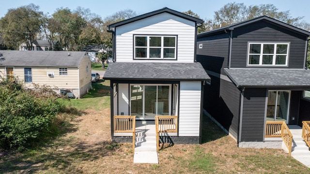 back of property featuring a lawn and a shingled roof