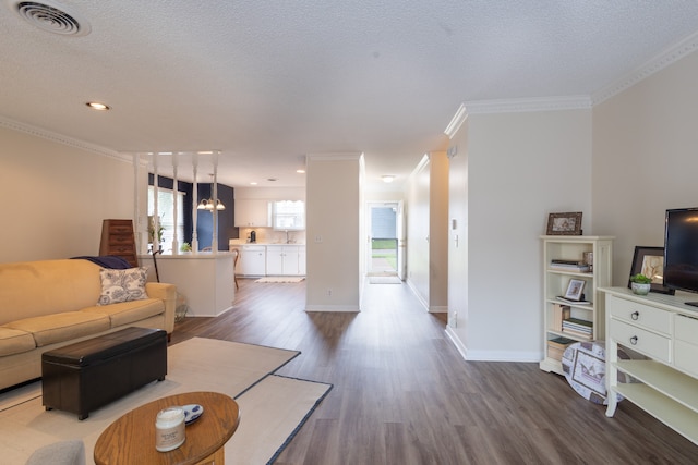 living room with ornamental molding, hardwood / wood-style flooring, and a textured ceiling