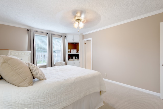 bedroom featuring ornamental molding, ceiling fan, carpet floors, and a textured ceiling