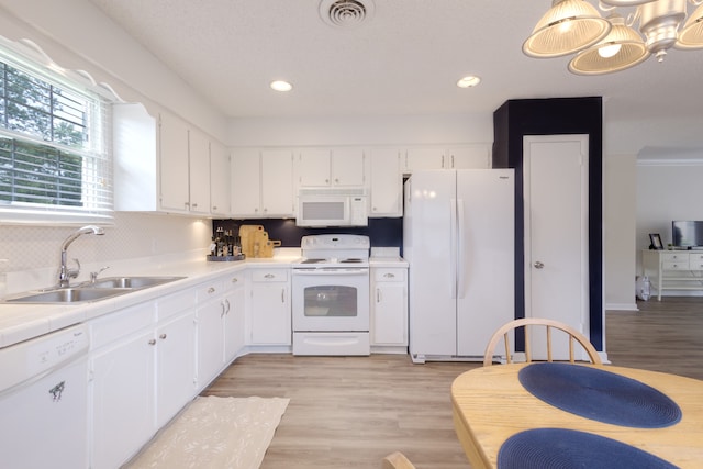 kitchen with light wood-type flooring, white cabinets, white appliances, sink, and crown molding