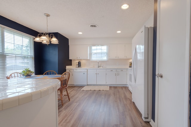 kitchen featuring plenty of natural light and white cabinetry