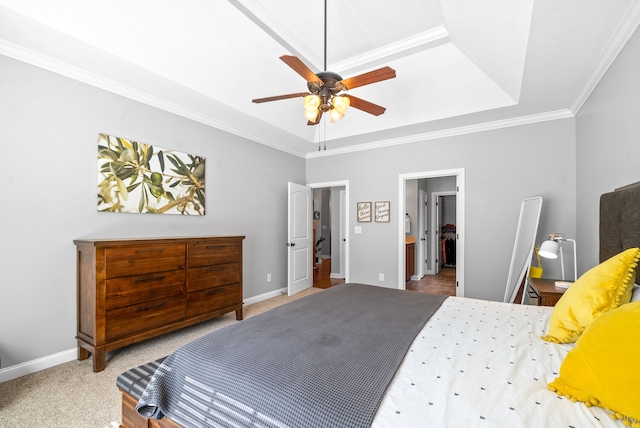 bedroom with ornamental molding, ceiling fan, carpet floors, and a tray ceiling