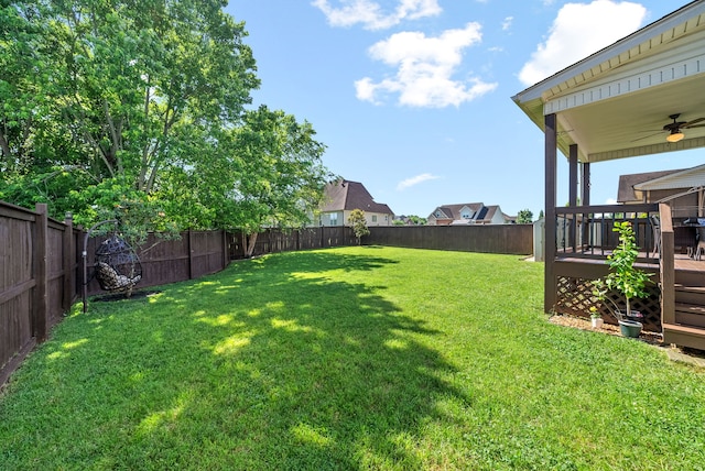 view of yard with ceiling fan and a wooden deck