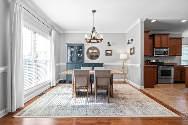 dining room with ornamental molding, a chandelier, and a healthy amount of sunlight