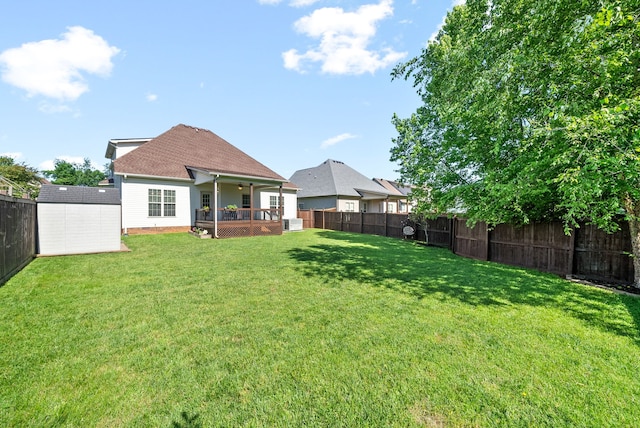 view of yard featuring a deck, a shed, and central AC