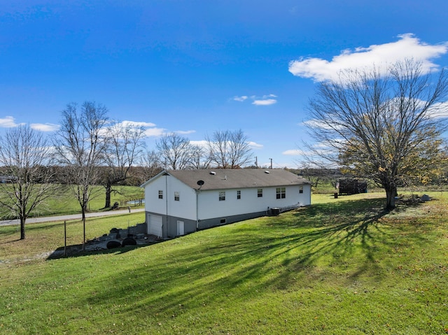 view of side of home featuring a yard and a garage