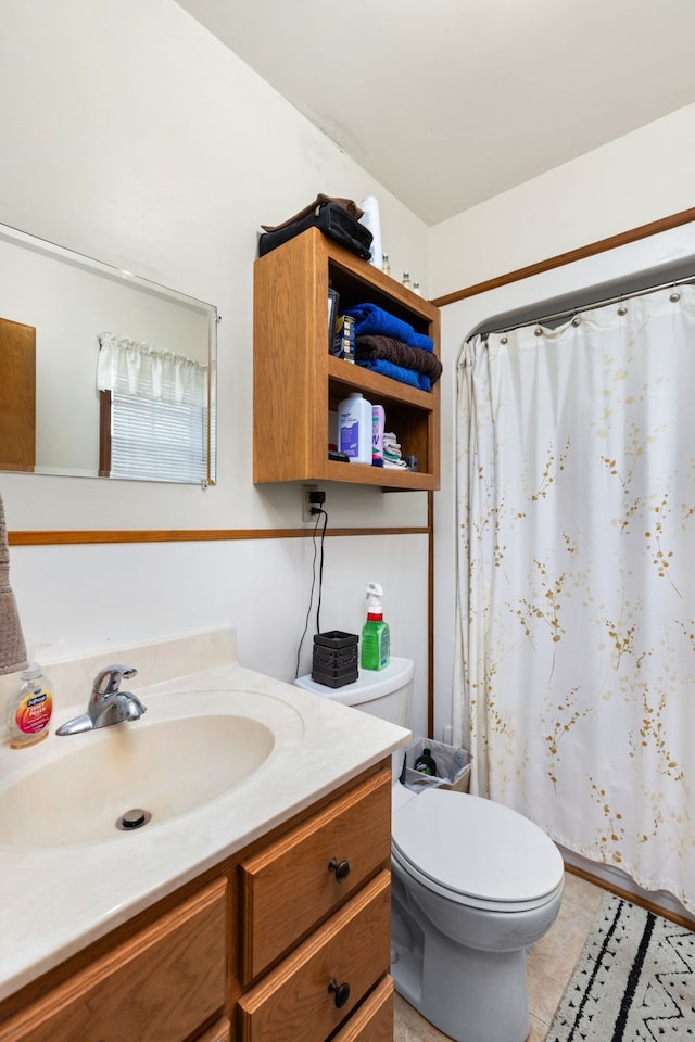 bathroom featuring tile patterned flooring, vanity, toilet, and curtained shower