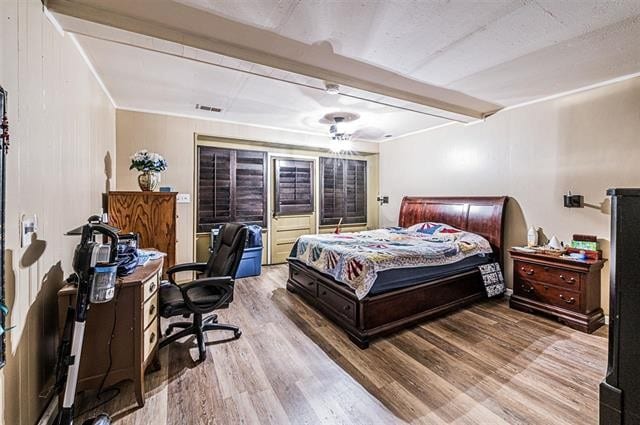 bedroom featuring beam ceiling and light hardwood / wood-style floors