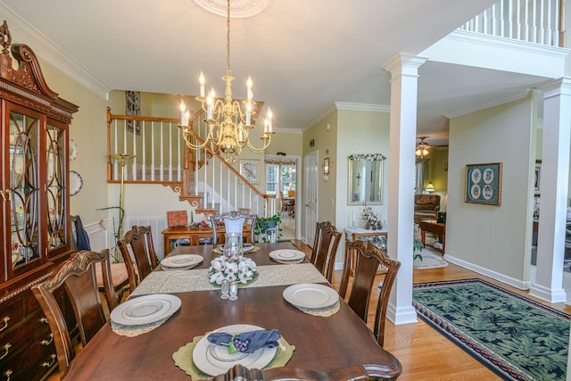 dining room with crown molding, ceiling fan with notable chandelier, light wood-type flooring, and ornate columns